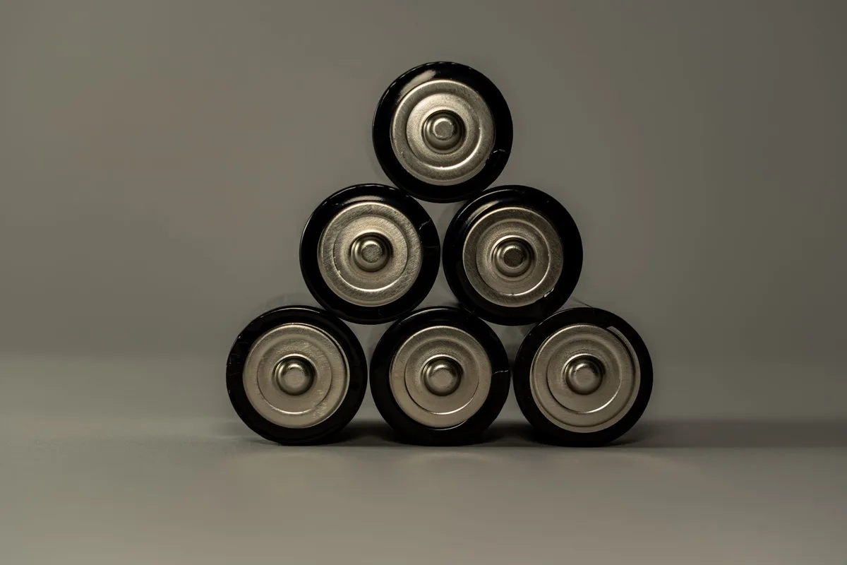 Main branchant un chargeur sur une batterie de vélo électrique