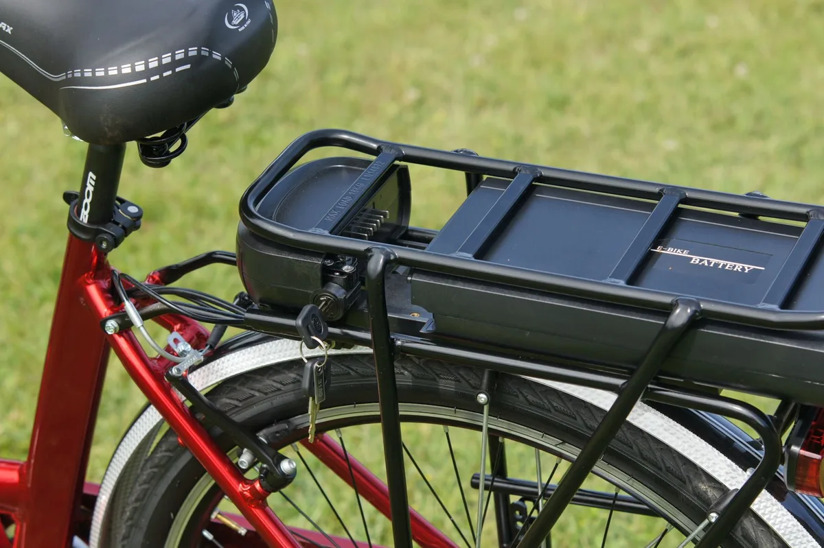 Personne recharge une batterie de vélo électrique avec un chargeur dédié à l'intérieur