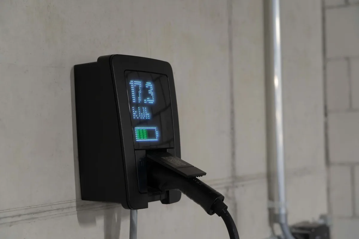 Personne connectant un chargeur d'origine à la batterie d'un vélo électrique