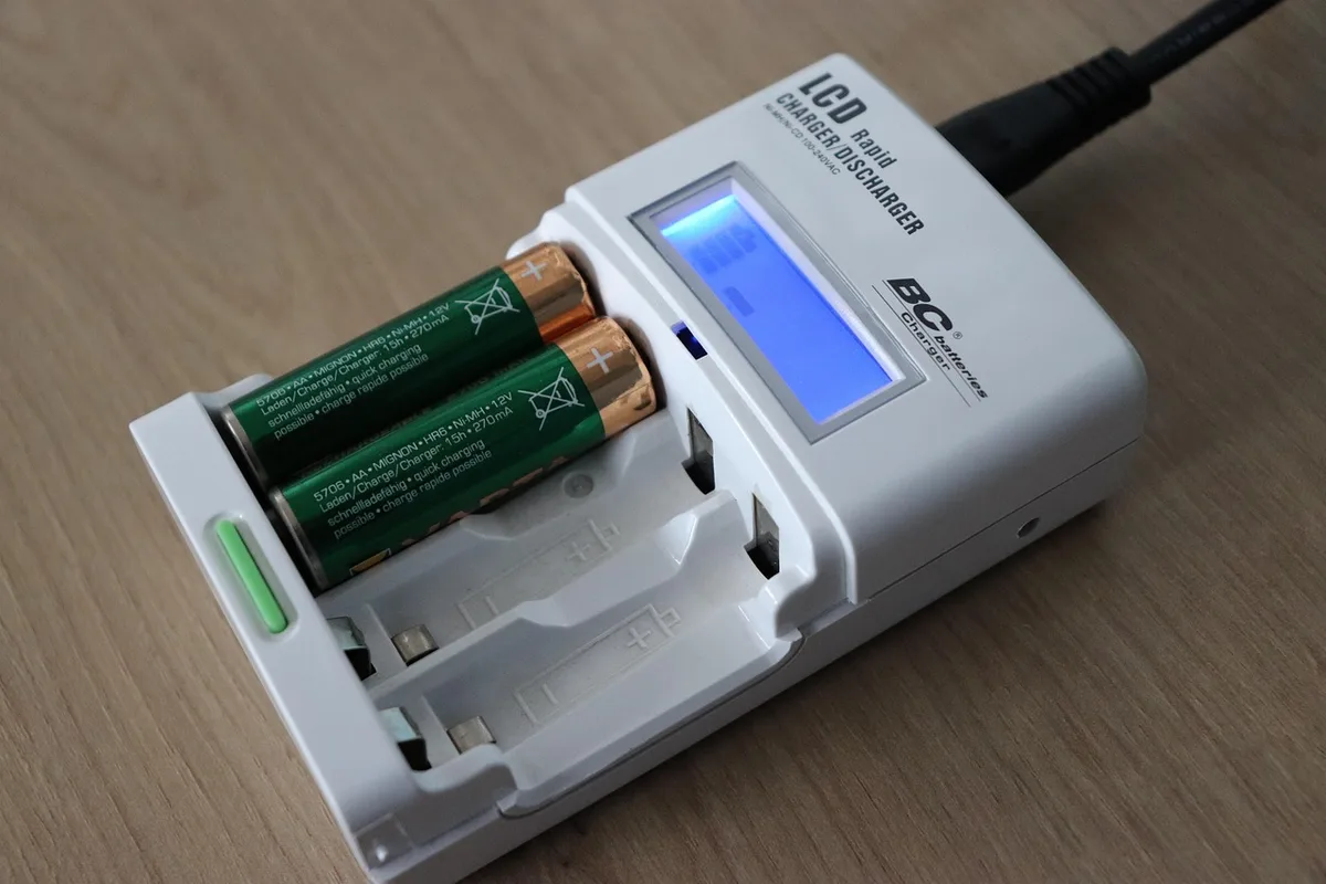 Personne recharge une batterie de vélo électrique avec un chargeur d'origine
