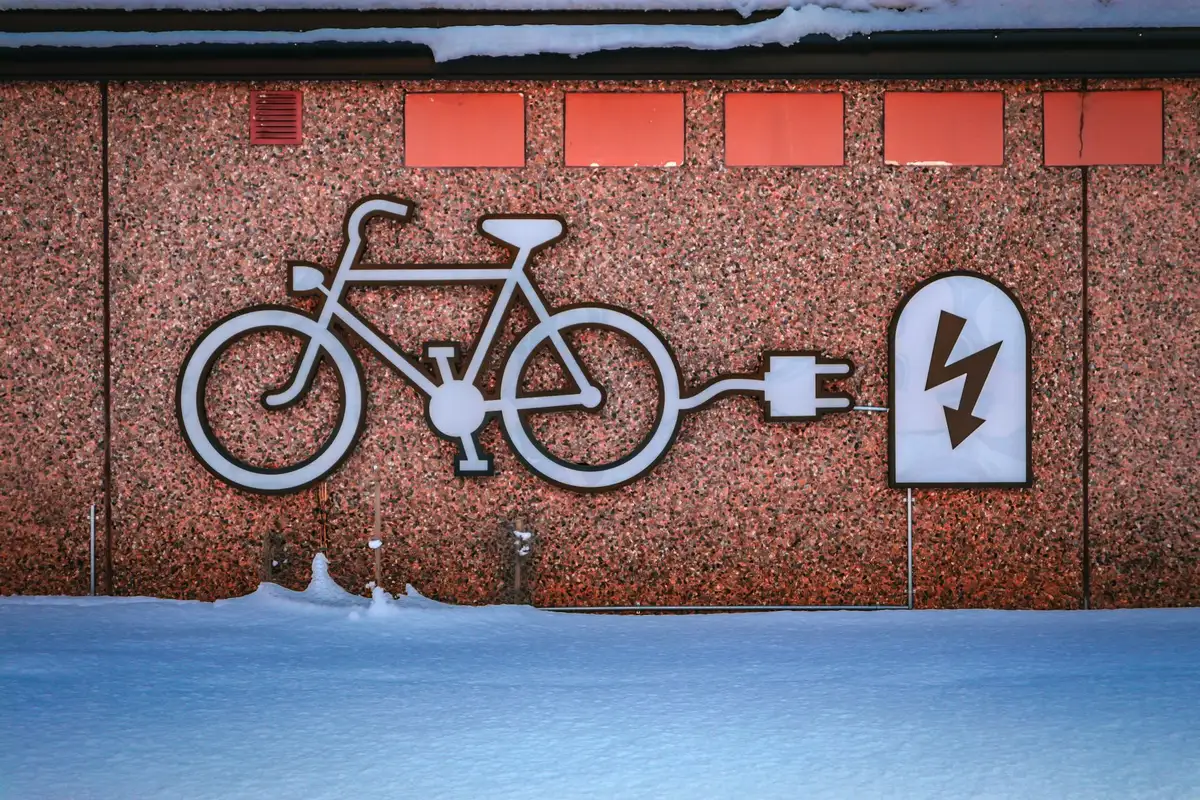 Personne branchant un chargeur sur la batterie d'un vélo électrique