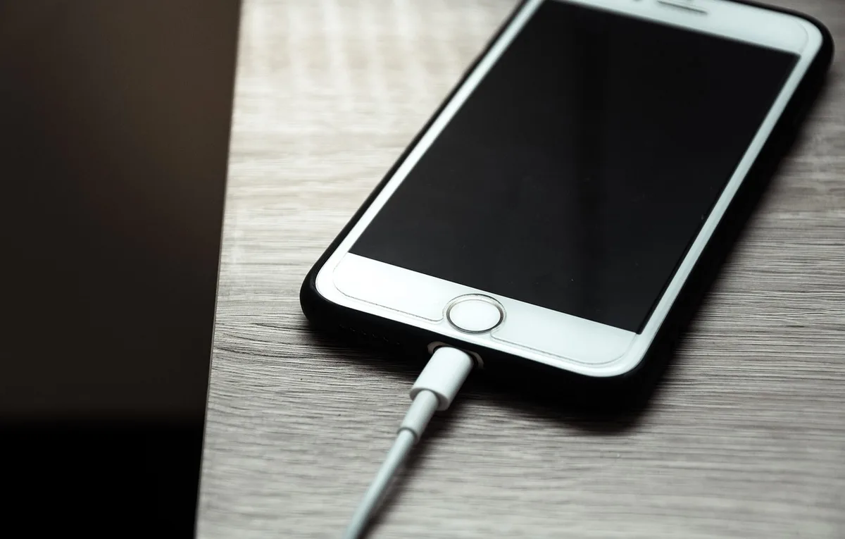 Personne branchant un chargeur sur une batterie de vélo électrique