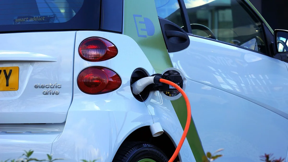Personne branchant le chargeur sur une batterie de vélo électrique