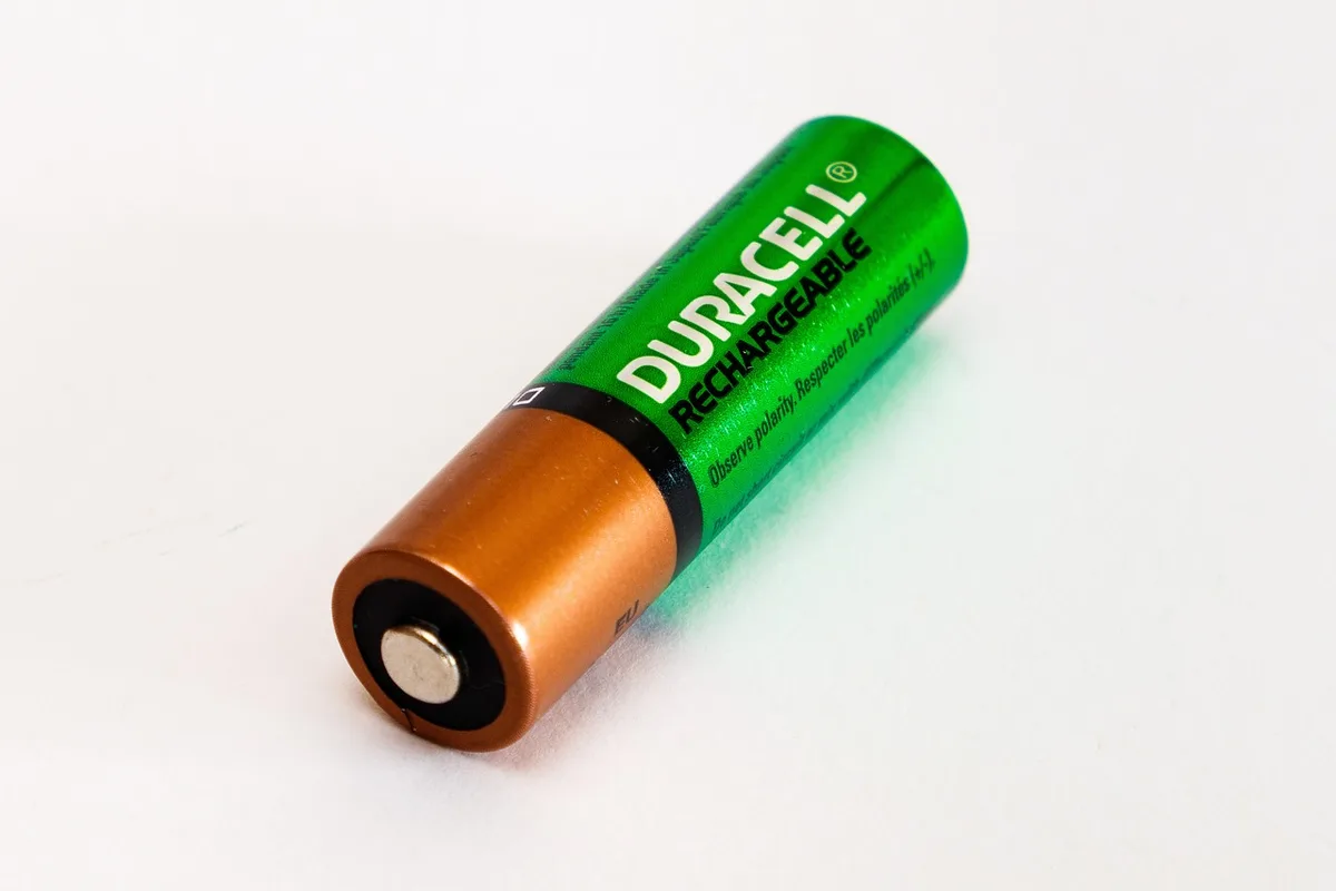 Main connectant un chargeur à la batterie d'un vélo électrique