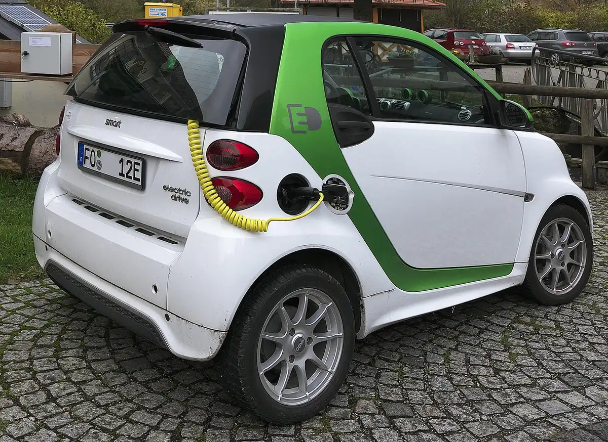 Personne anonyme branchant le chargeur sur une batterie de vélo électrique