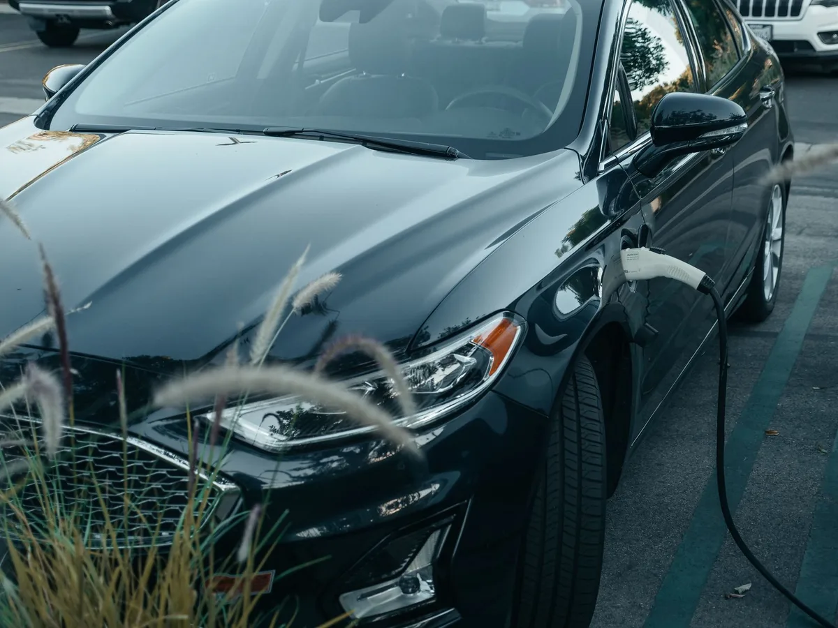 Guidon de vélo électrique avec batterie amovible posée près d'un chargeur dans un garage lumineux