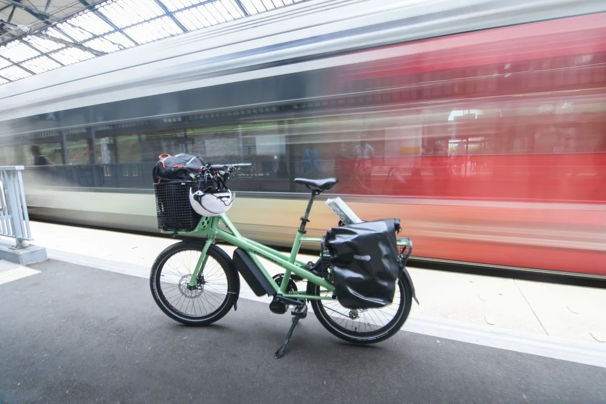 Batterie de vélo électrique posée sur un établi avec chargeur et chiffon