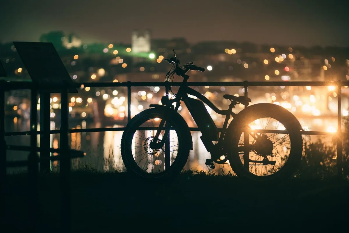 Vélo électrique en cours de charge dans un garage, batterie amovible à côté