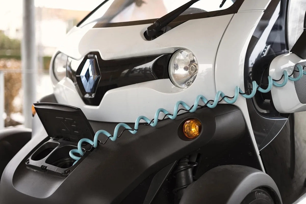 Batterie de vélo électrique posée près d'un vélo et d'une prise dans un garage propre