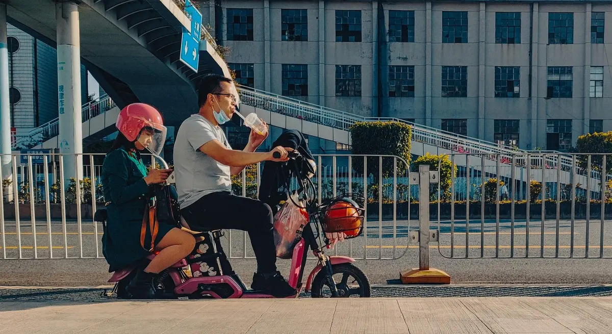 Mains hands insérant une batterie de vélo électrique dans un cadre dans un garage bien éclairé