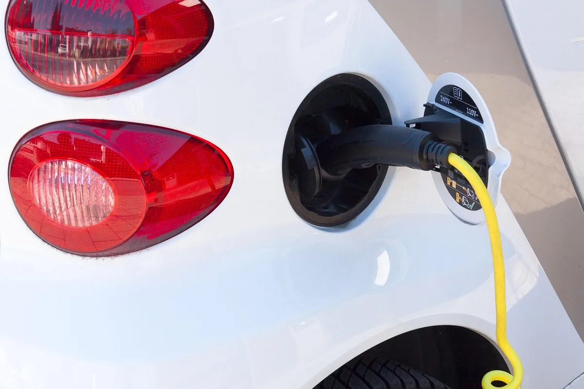Batterie de vélo électrique posée sur un établi avec chargeur dans un garage