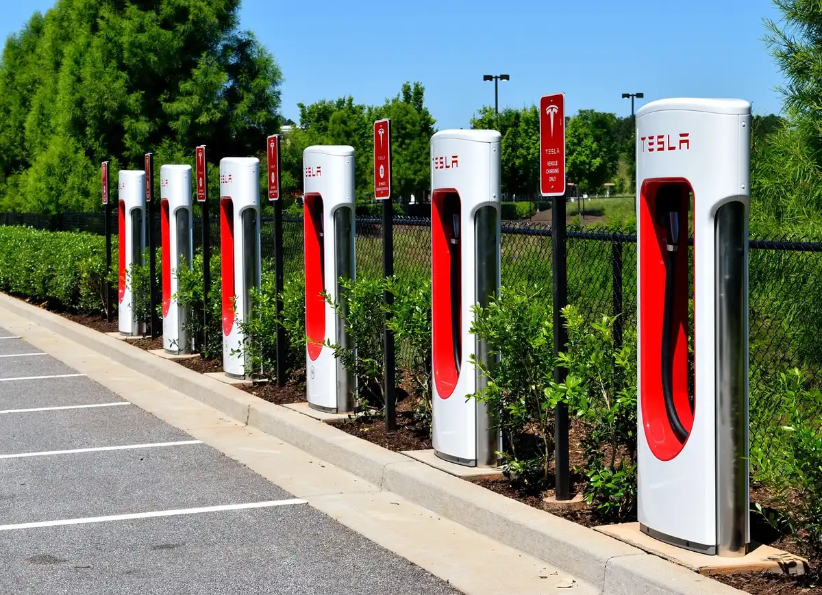Batterie de vélo électrique posée sur un établi, main gantée vérifiant le port de charge