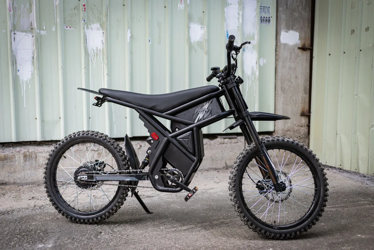 Guidon de vélo électrique et batterie amovible posés dans un atelier, silhouette claire
