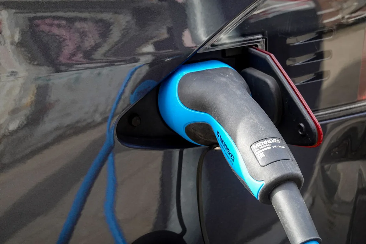 Batterie de vélo électrique sur un établi avec câble de charge et thermomètre