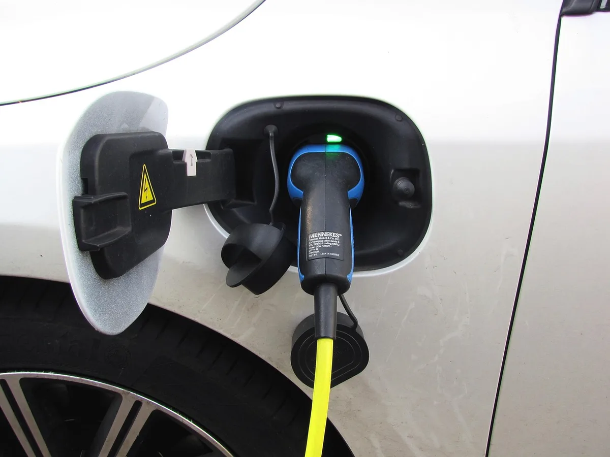 Batterie de vélo électrique sur une table d'atelier avec câble et carnet de maintenance